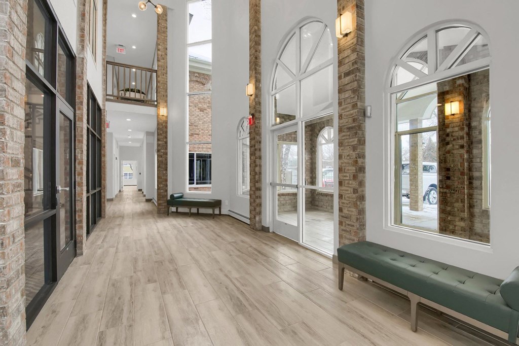 the lobby of a building with large windows and benches