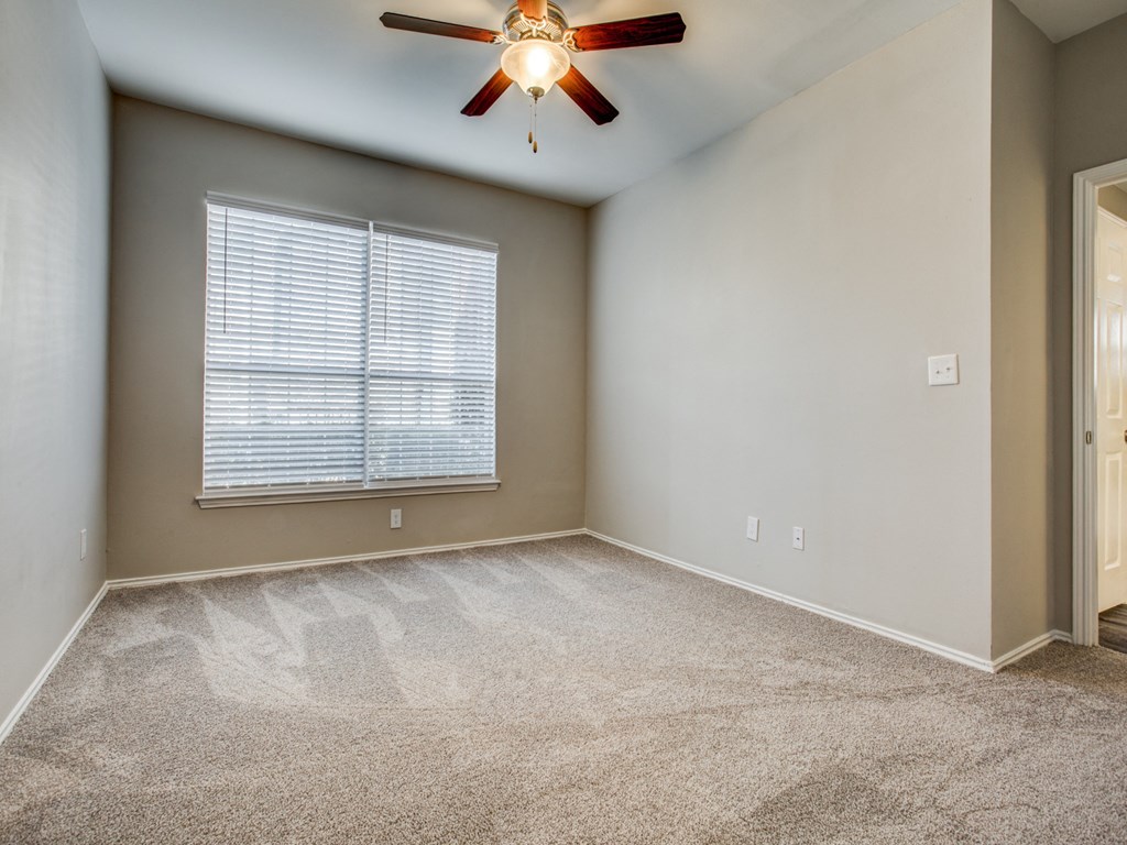 Apartments for Rent in Plano TX - Carrington Park - Bedroom with Carpeting, Beige Walls, and Large Window