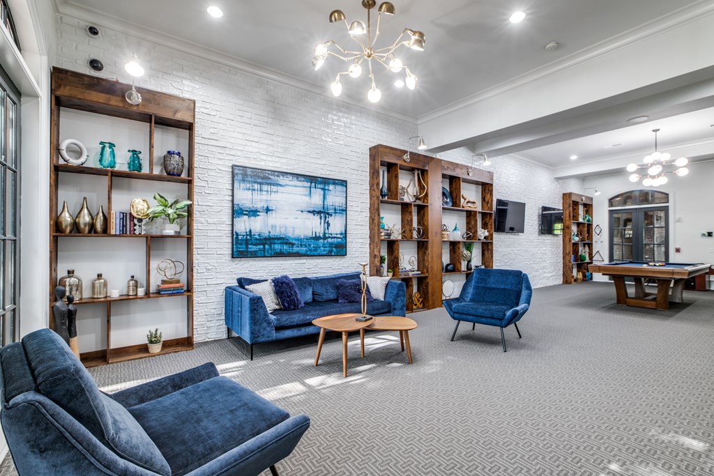 A living room with a blue sofa and grey carpet.