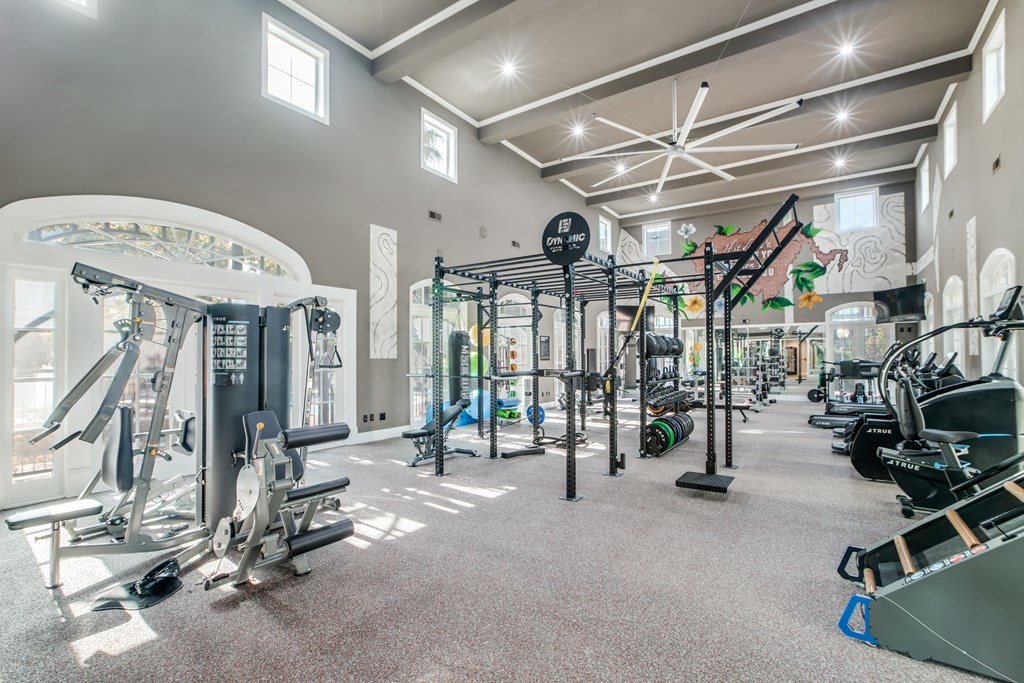 A gym with a variety of equipment including weights and machines.