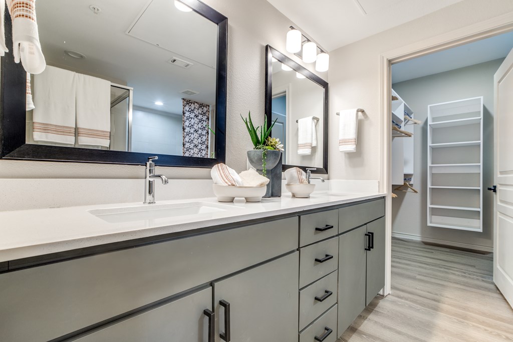 A bathroom with a sink, mirror, and towel rack.