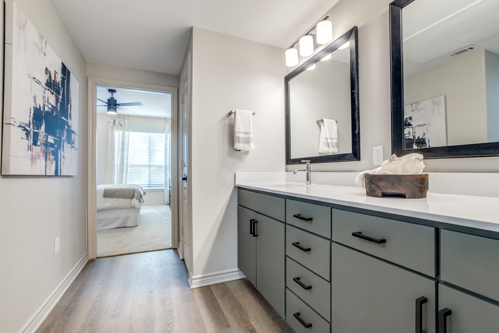 A bathroom with a large mirror and a painting on the wall.