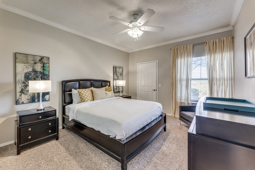 a bedroom with a large bed and a ceiling fan