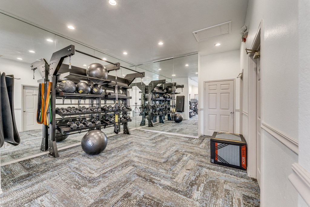 a workout room with weights and equipment and a door to a closet