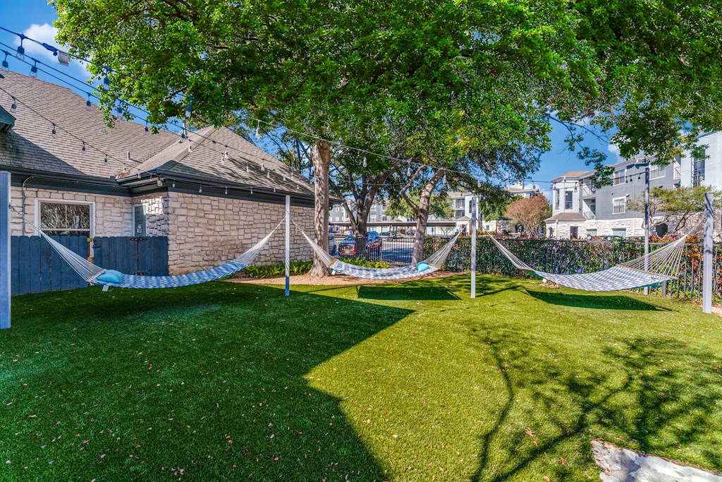 a yard with hammocks in the yard of a house