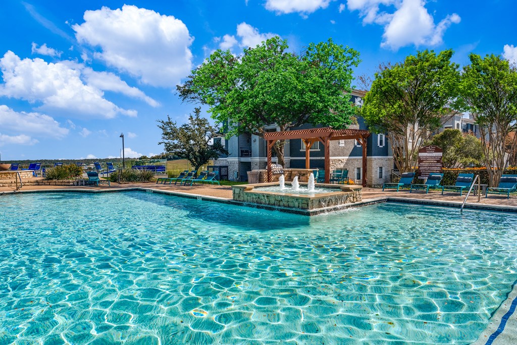 a swimming pool with a fountain in front of a house