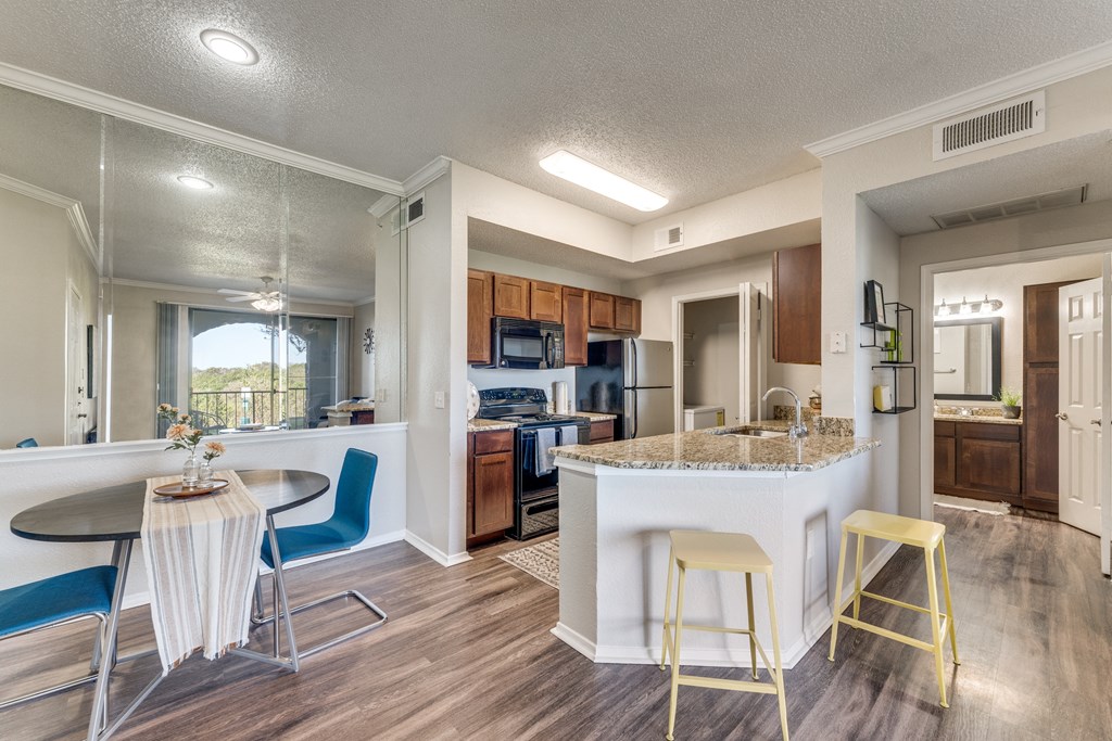 a kitchen with a breakfast bar and a table with chairs