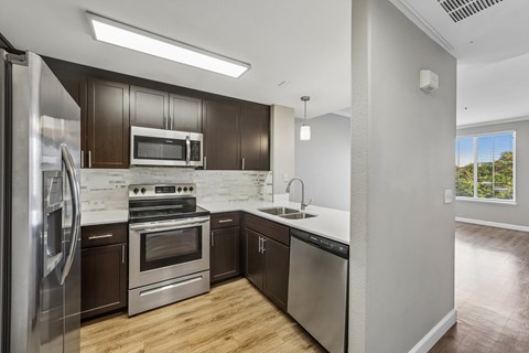 A modern kitchen with stainless steel appliances and wooden cabinets.
