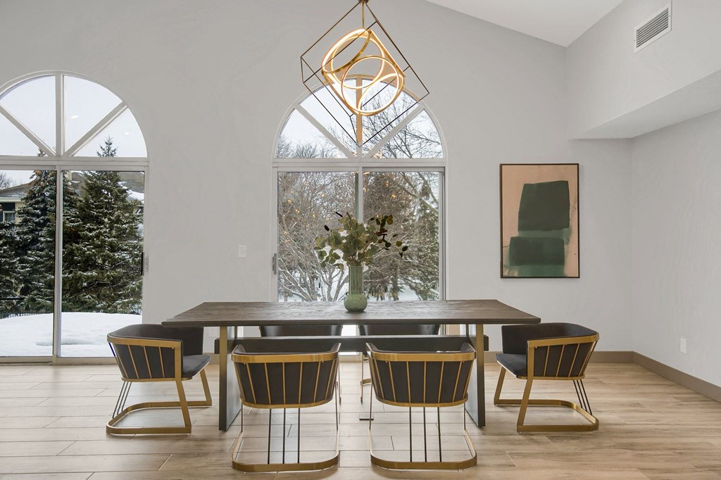 a dining room with a large window and a table with chairs