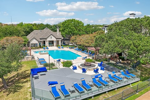A pool with blue loungers and a fountain in the middle.