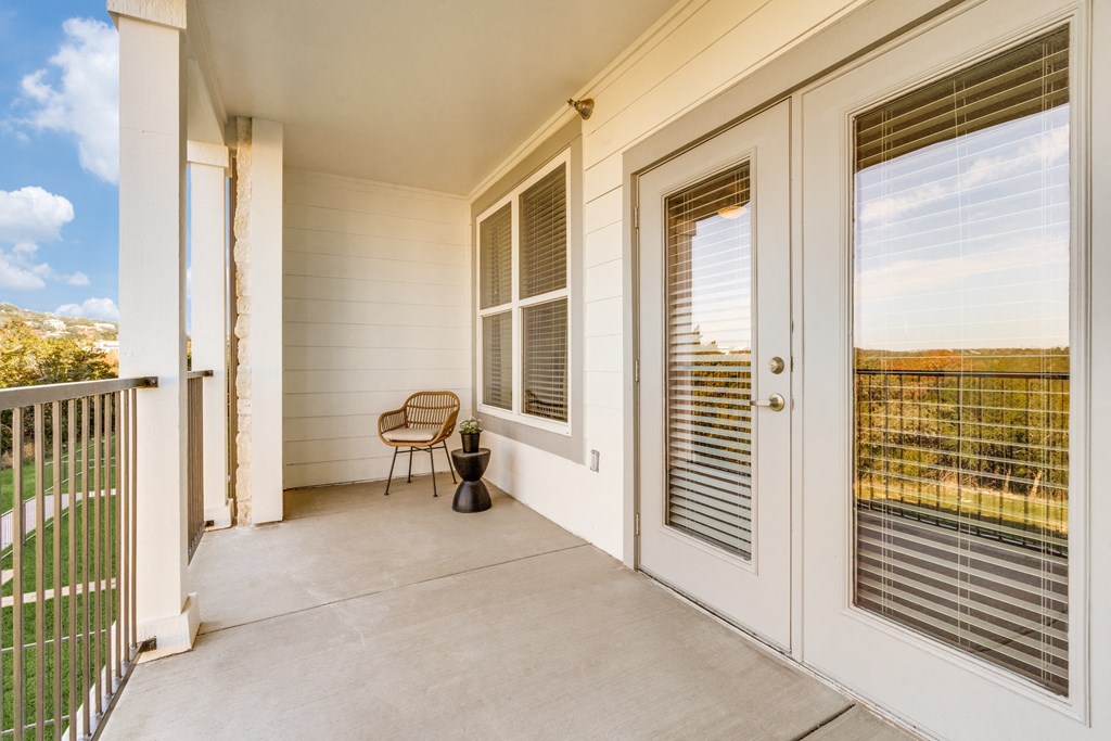a porch with two doors and a chair on it