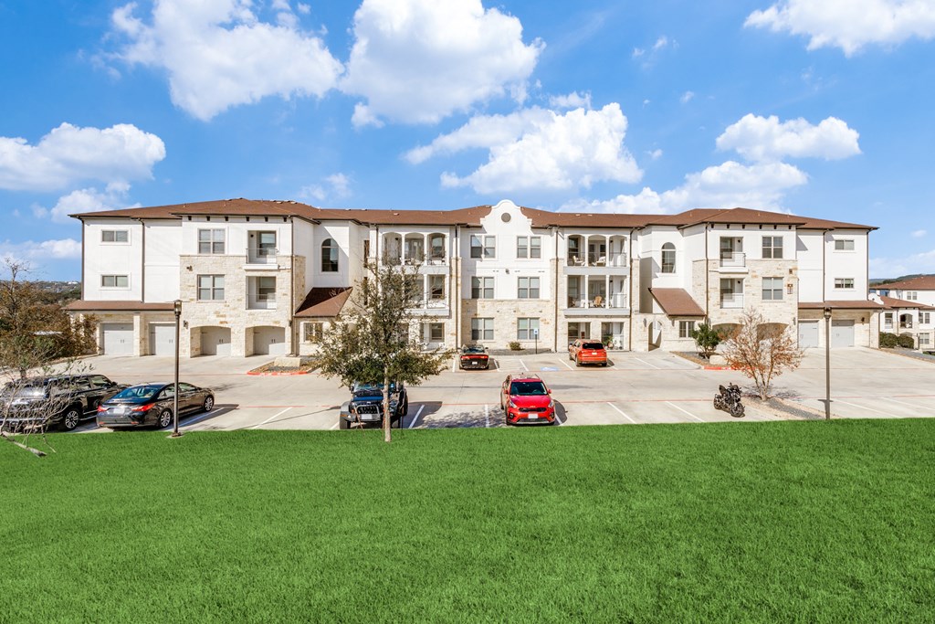 a large apartment building with cars parked in a parking lot