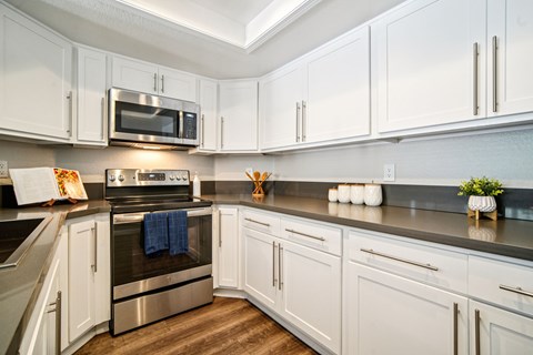 A kitchen with white cabinets and a stainless steel oven.