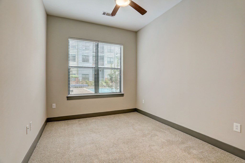 Pet-Friendly Apartments in Nashville, TN- Octave Apartments-  Bedroom with plush carpet and a ceiling fan