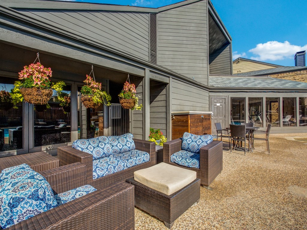 a patio with couches and chairs outside of a house