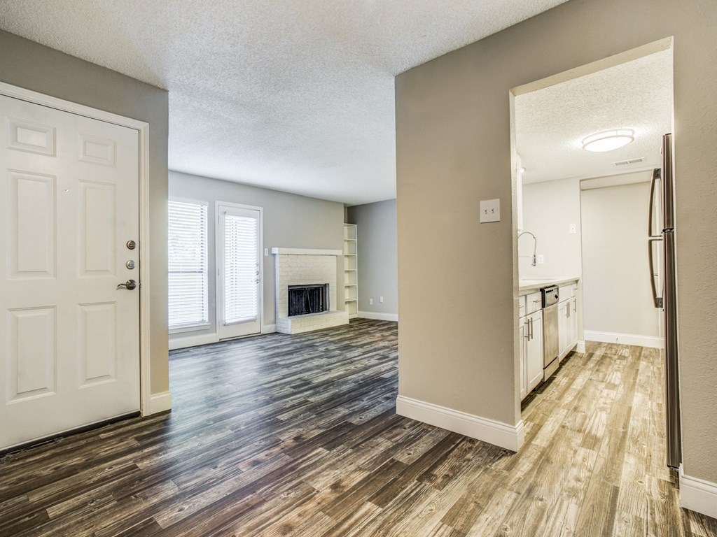 an empty living room and kitchen with a fireplace