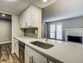 a kitchen with white cabinets and a sink and a fireplace