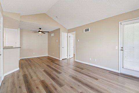A room with wooden floors and a ceiling fan.