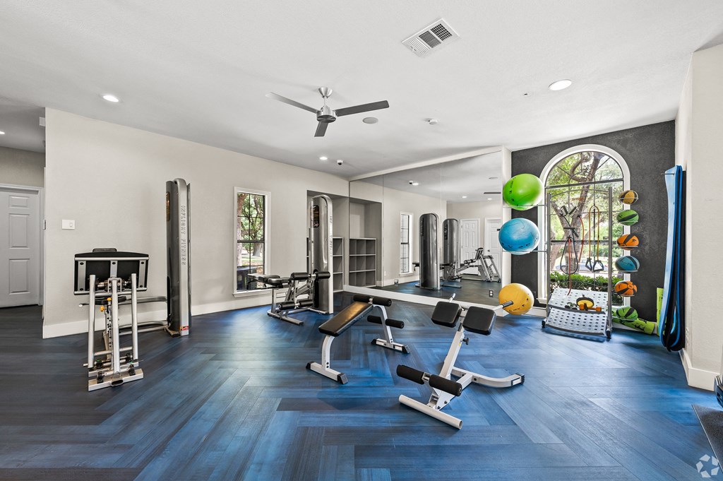 a home gym with exercise equipment and a large window