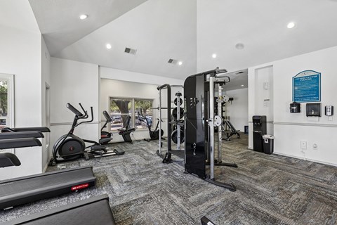 A gym with treadmills, elliptical machines, and other exercise equipment.