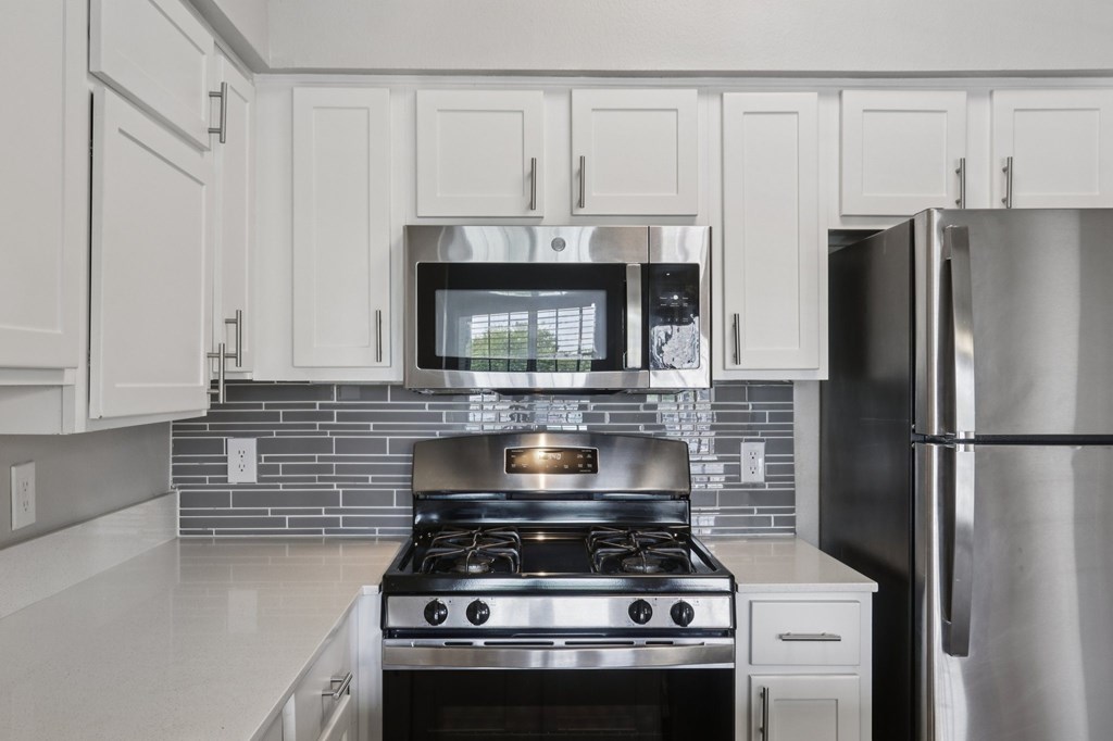 A modern kitchen with a stove and refrigerator.