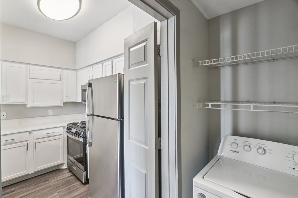 A white kitchen with a refrigerator, oven, and dishwasher.