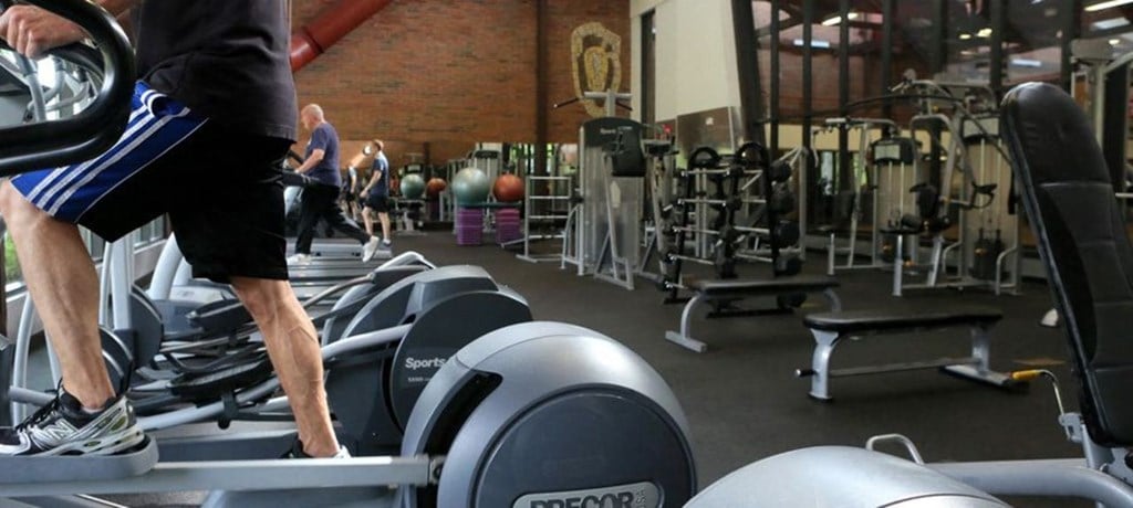 a man walking on a treadmill in a gym