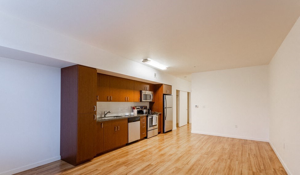 a kitchen with wood floors and white walls