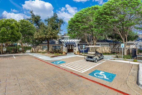 A parking lot with a car and a golf cart parked in the disabled parking spaces.