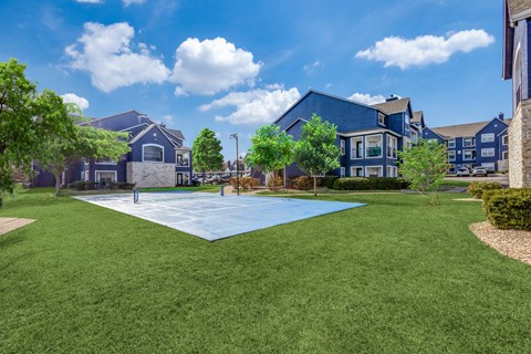 A large grassy area in front of a row of houses.