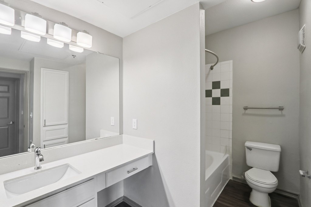 A white bathroom with a toilet, sink, and bathtub.