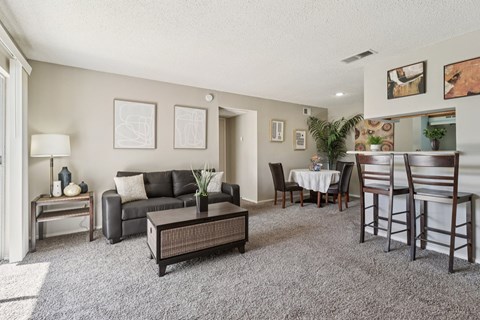 A living room with a grey carpet and furniture.