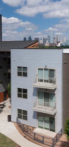 a white building with two balconies and a city in the background