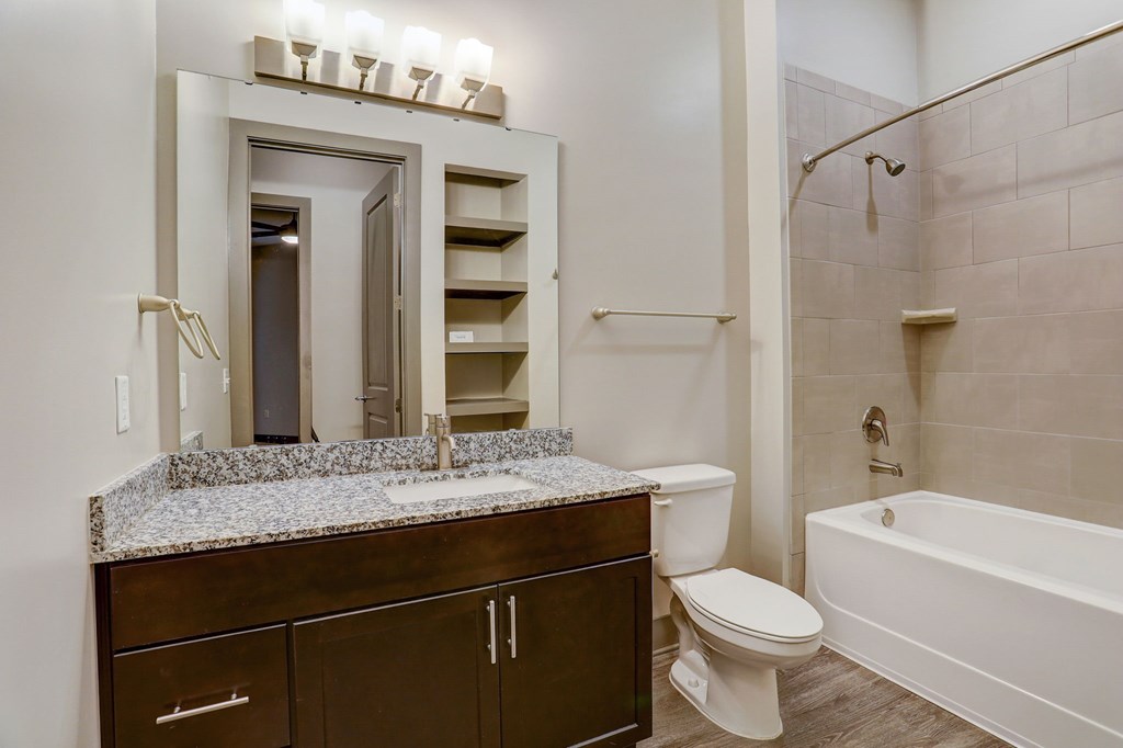 Pet-Friendly Apartments in Nashville, TN- Octave Apartments- bathroom with granite countertops cabinet space and beautifully lit vanity