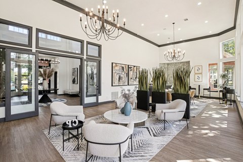 A modern living room with a white sofa set and a chandelier.