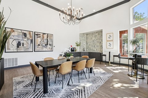 A dining room with a black table and chairs.