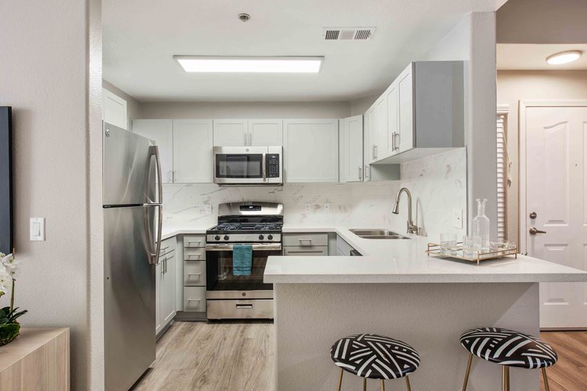 a kitchen with white cabinets and stainless steel appliances
