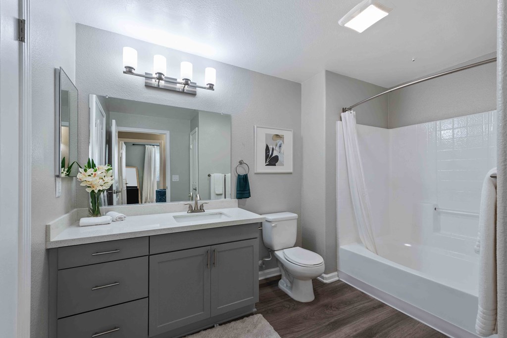 a bathroom with a large mirror and a toilet and a shower