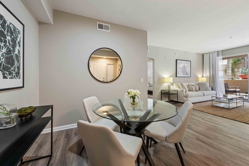 a dining room with a glass table and white chairs