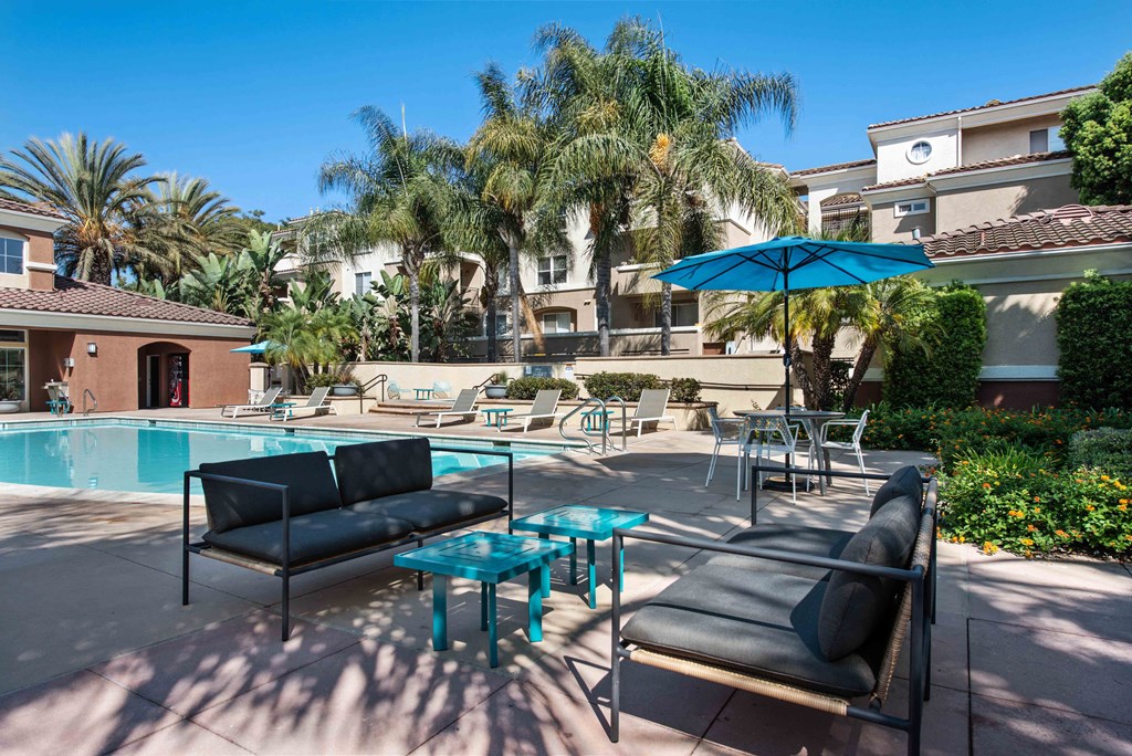 a swimming pool with lounge chairs and tables