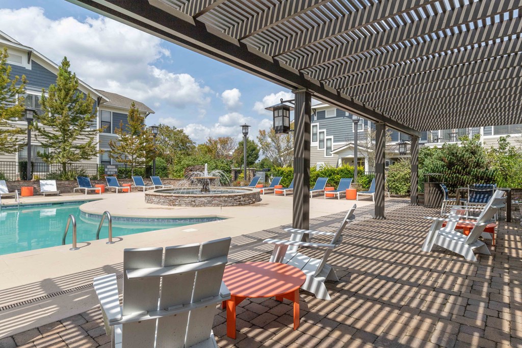 pergola covered seating area next to swimming pool