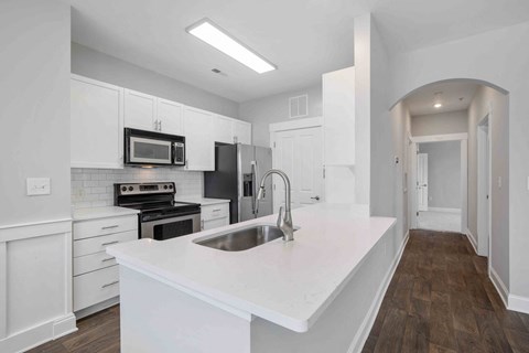a white kitchen with a sink and a microwave