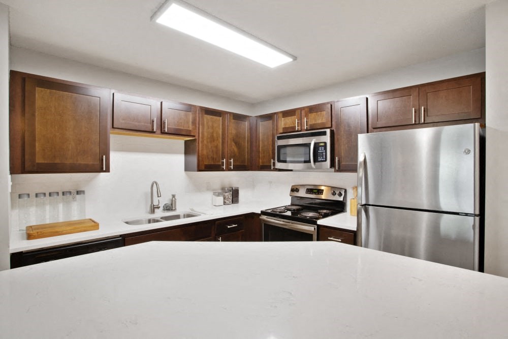 a kitchen with stainless steel appliances and white counter tops