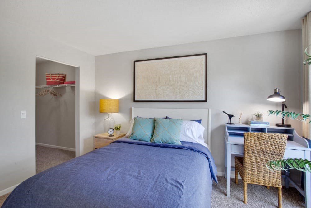 a bedroom with a bed and a desk and a closet