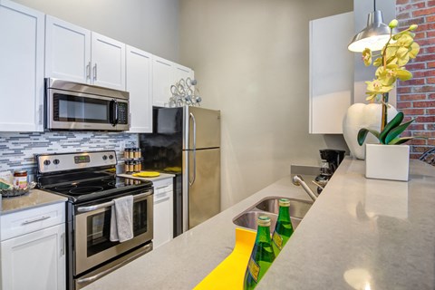 a modern kitchen with stainless steel appliances and white cabinets