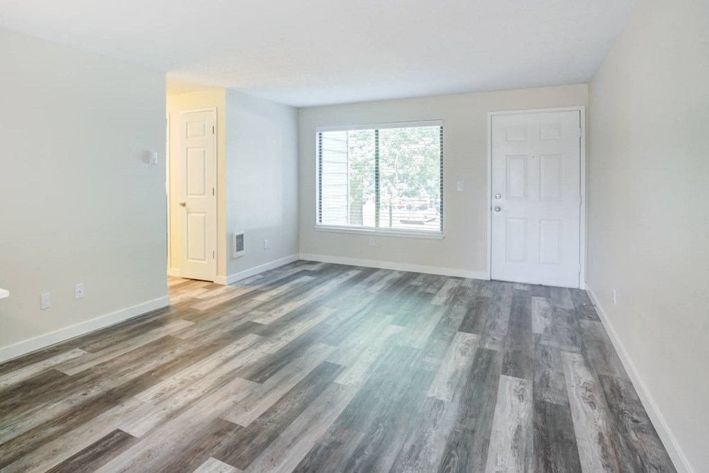 a bedroom with hardwood floors and a large window