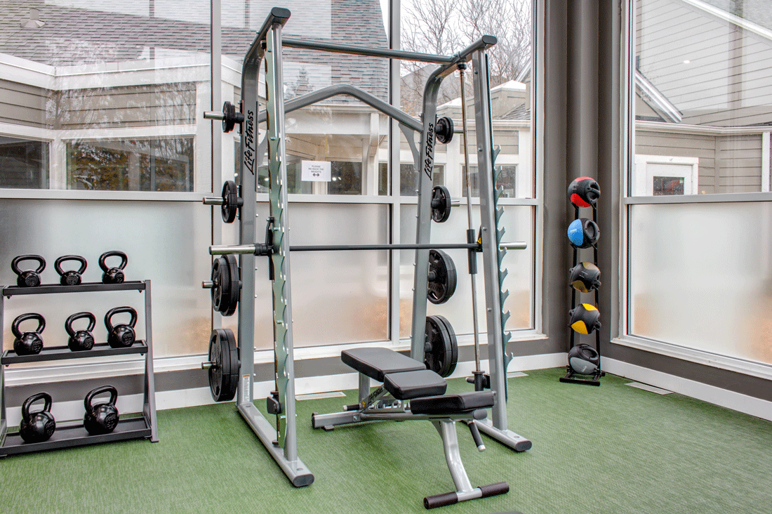 Free weights in fitness center, smith machine