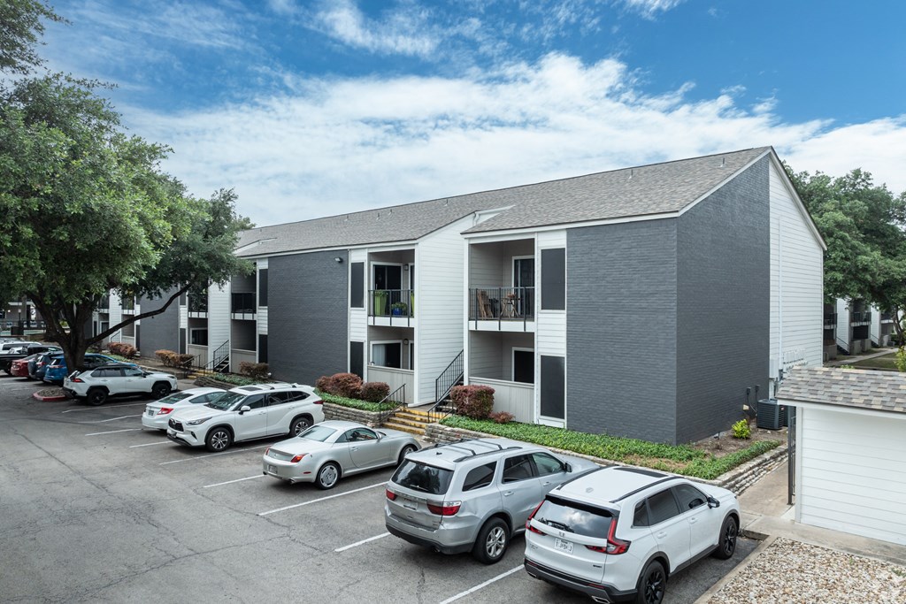 a gray building with cars parked in front of it