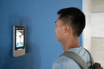 a man looking at a cell phone on a blue wall