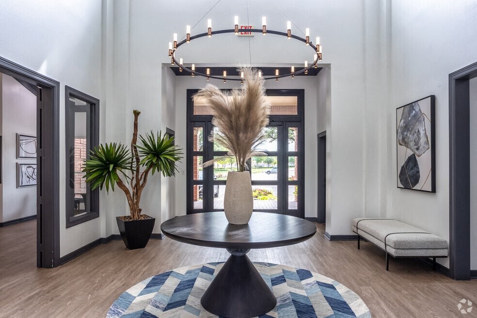 a living room with a round table and a chandelier